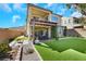 Spacious backyard with patio, fire pit, and manicured artificial turf at 3512 Portiani Dr, Las Vegas, NV 89141