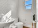 Half bathroom featuring mosaic tile wall, toilet, and sink with modern faucet at 3512 Portiani Dr, Las Vegas, NV 89141