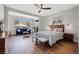 Bright bedroom with seating area, wood floors, ceiling fan, and queen bed at 3512 Portiani Dr, Las Vegas, NV 89141