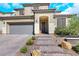 Two-story home with desert landscaping, tile roof, and a two car garage with brick paver driveway at 3512 Portiani Dr, Las Vegas, NV 89141