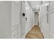 Hallway with wood floors, white walls and cabinets, and modern hardware at 3512 Portiani Dr, Las Vegas, NV 89141