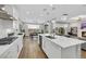 Stylish kitchen with white cabinets, quartz countertops, and a breakfast bar, seamlessly connecting to the dining and living areas at 3512 Portiani Dr, Las Vegas, NV 89141