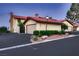 Townhouse with a two-car garage and red tile roof with manicured landscaping at 3942 Delos Dr, Las Vegas, NV 89103
