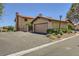Charming single-story home with a 2-car garage, landscaped front yard, and a red tile roof under a clear blue sky at 3942 Delos Dr, Las Vegas, NV 89103