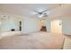 Spacious living room featuring neutral carpet, a ceiling fan, and an open floor plan with views into other rooms at 3942 Delos Dr, Las Vegas, NV 89103