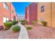 Exterior walkway between colorful condominiums with green landscaping at 4050 Pacific Harbors Dr # 107, Las Vegas, NV 89121