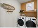 Functional laundry room equipped with a washer, dryer, shelving, and home decor at 4180 E Brusca Way, Pahrump, NV 89061