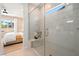 Modern shower with white tile, bench, and glass door next to a bedroom with large windows at 4180 E Brusca Way, Pahrump, NV 89061