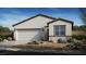 Charming single-story home featuring a two-car garage, desert landscaping, and a modern exterior design at 4200 E Brusca Way, Pahrump, NV 89061