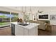Open kitchen with a center island, a view to the living room, and a backyard view through sliding glass doors at 4200 E Brusca Way, Pahrump, NV 89061