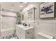 Bathroom with shower-tub, marble surround, double vanity, and framed art print at 4507 Grotto Ct, North Las Vegas, NV 89031