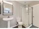 Well-lit bathroom featuring a sleek pedestal sink, modern toilet, and a glass-enclosed shower for a clean design at 4507 Grotto Ct, North Las Vegas, NV 89031