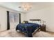 Cozy bedroom featuring a ceiling fan, a comfortable bed with a blue comforter, and natural light from the window at 4507 Grotto Ct, North Las Vegas, NV 89031