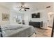 Large primary bedroom features a ceiling fan, TV, and vanity area near ensuite bath at 4507 Grotto Ct, North Las Vegas, NV 89031