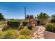 Backyard showcasing lush landscaping, a stone walkway, and desert vegetation at 502 E Fairway Rd, Henderson, NV 89015