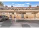 View of unit #515 covered parking, gated entrance, desert landscaping, in front of tan cinder block facade at 515 Kristin Ln, Henderson, NV 89011