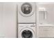Convenient laundry area with stacked washer and dryer and white cabinets at 515 Kristin Ln, Henderson, NV 89011