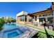 Beautiful backyard features a pool with spa, outdoor kitchen, and covered patio with furniture at 5155 Rock Daisy Dr, Las Vegas, NV 89135