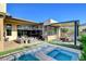 Expansive backyard with a pool, spa, covered patio, outdoor kitchen, and a serene outdoor experience at 5155 Rock Daisy Dr, Las Vegas, NV 89135
