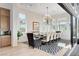 Bright dining room with a large table, stylish chandelier, and sliding glass doors to the patio at 5155 Rock Daisy Dr, Las Vegas, NV 89135