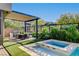 Outdoor dining area with built-in grill, hot tub, and beautifully landscaped backyard at 5155 Rock Daisy Dr, Las Vegas, NV 89135