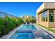 Sparkling pool and hot tub surrounded by lush landscaping create a private backyard oasis at 5155 Rock Daisy Dr, Las Vegas, NV 89135