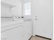 Bright laundry room with washer, dryer, shelving, and door to exterior at 5513 Escallonia St, Las Vegas, NV 89149