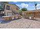 View of backyard features a two story unit, an outdoor kitchen, brick layout, and string lights at 5854 Sheila Ave, Las Vegas, NV 89108
