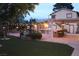 Spacious backyard with an outdoor kitchen, fountain, pergola with string lights, and artificial grass at 5854 Sheila Ave, Las Vegas, NV 89108