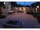 Wide backyard shot with a fire pit, patio seating, outdoor kitchen, fountain, and decorative lighting at 5854 Sheila Ave, Las Vegas, NV 89108