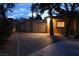 Night view of the property's paved driveway and decorative fence. Mature trees give the property privacy at 5854 Sheila Ave, Las Vegas, NV 89108