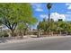 View of home showcasing wrought iron gate, mature trees, and circular driveway at 5854 Sheila Ave, Las Vegas, NV 89108