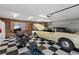 Spacious garage featuring a black and white checkered floor, wood paneling, and room for multiple vehicles at 5854 Sheila Ave, Las Vegas, NV 89108