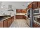 Modern kitchen with wood cabinets, stainless steel appliances, granite counters, and tile floors at 5854 Sheila Ave, Las Vegas, NV 89108