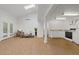 Open living space with vaulted ceilings, wood floors, and a kitchenette with white cabinets at 5854 Sheila Ave, Las Vegas, NV 89108