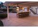 Outdoor covered bar area featuring built-in grill, ceiling fans, granite counters and barstool seating at 5854 Sheila Ave, Las Vegas, NV 89108