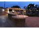 Spacious backyard with a built-in stone outdoor kitchen, a barbecue and bistro lighting at 5854 Sheila Ave, Las Vegas, NV 89108