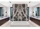 Modern bathroom with dual vanities, soaking tub, and decorative marble wall at 6 Rock Mount Ct, Henderson, NV 89012