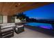 Chic covered patio with modern furniture, outdoor kitchen, and a sleek pool with a view of the Las Vegas skyline at 6 Rock Mount Ct, Henderson, NV 89012