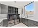 Well-organized laundry room with gray cabinets, modern washer and dryer, sink and scenic window view at 6 Rock Mount Ct, Henderson, NV 89012