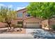 Charming two-story home with a two-car garage, desert landscaping, and mature trees at 6125 Paddleboat St, North Las Vegas, NV 89031
