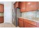 Close-up of kitchen featuring stainless steel appliances, wood cabinets, and stone countertops at 6125 Paddleboat St, North Las Vegas, NV 89031
