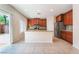 Well-lit kitchen featuring wood cabinets, granite countertops, and a breakfast bar that opens to the outdoors at 6125 Paddleboat St, North Las Vegas, NV 89031