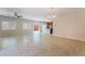 Expansive living area with tile flooring connecting to a kitchen, ceiling fan, and plantation shutters at 6125 Paddleboat St, North Las Vegas, NV 89031