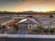 Home featuring solar panels, a two-car garage, and desert landscaping against a scenic mountain backdrop at 617 Sylvan St, Henderson, NV 89002