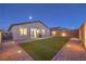 Well-lit backyard with artificial turf, stone landscaping, and an outdoor grill, perfect for entertaining at 617 Sylvan St, Henderson, NV 89002