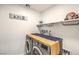 Well-organized laundry room with washer, dryer, shelving, and decor, for efficient chores at 617 Sylvan St, Henderson, NV 89002