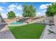 Private backyard with an in-ground pool, artificial turf, and mature trees at 6791 Greengrove Dr, Las Vegas, NV 89103