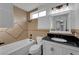 Bathroom with tiled shower and tub, vanity with black countertop, and framed mirror, offering a spa-like experience at 6791 Greengrove Dr, Las Vegas, NV 89103