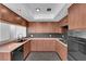 Spacious U-shaped kitchen featuring wooden cabinets, tiled floors, and black appliances at 6791 Greengrove Dr, Las Vegas, NV 89103